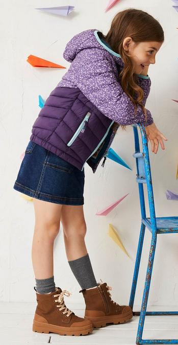 Girl wearing purple contrast colour block and ditsy print padded jacket. Paired with Jean skirt.