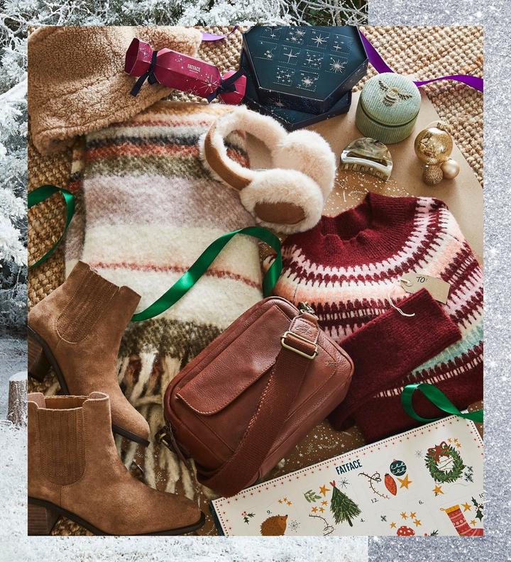 A selection of luxury gifts for women, including a hat, scarf & fluffy ear muffs, suede ankle boots, & leather handbag.