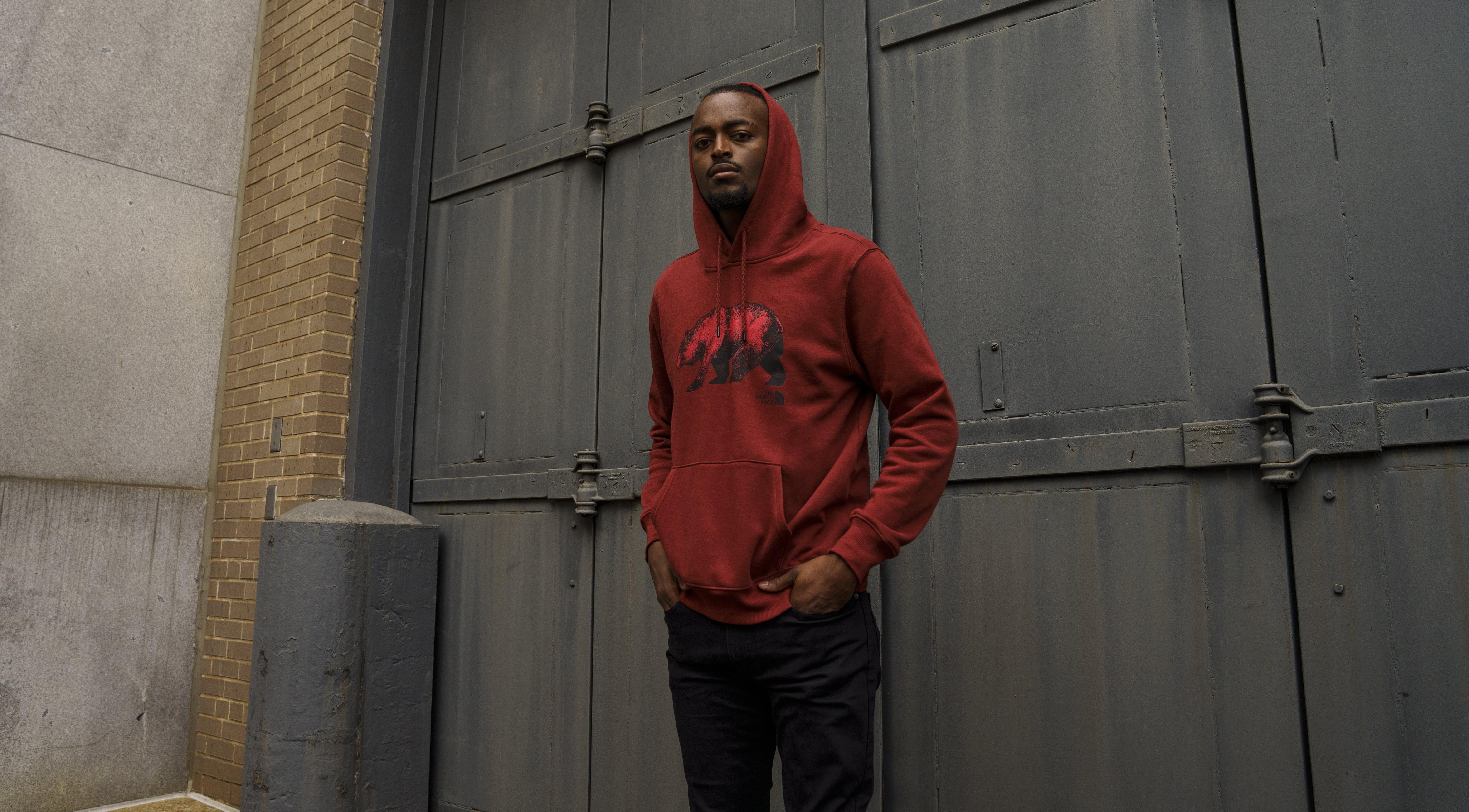 Man in black jeans and red The North Face hoodie.