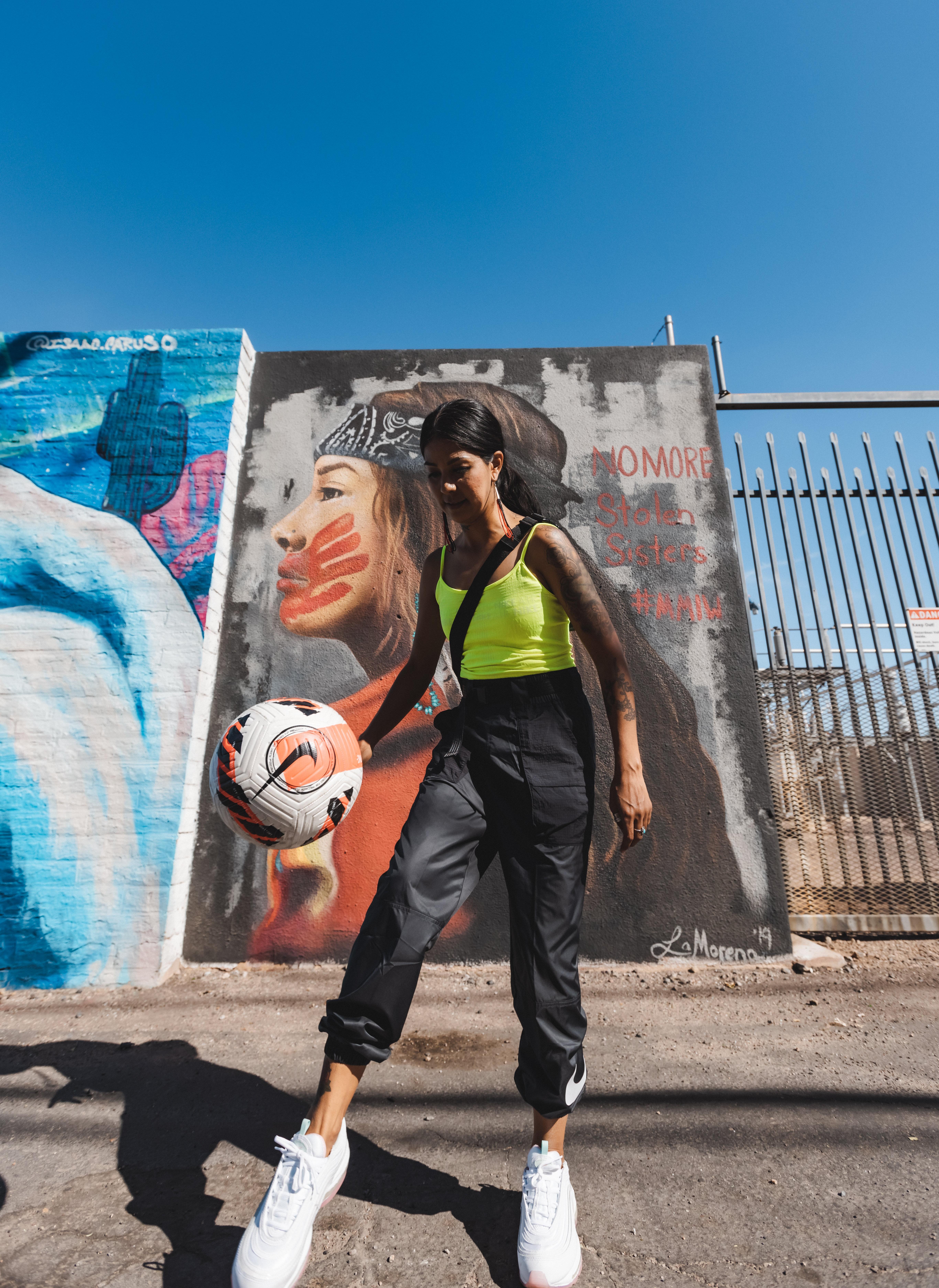 Lucinda in Women's Nike Apparel in front of mural.