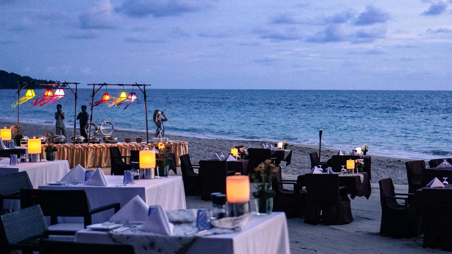 A beautiful beachside restaurant at Koh Lanta, Thailand, with lanterns lighting up the tables at sundown