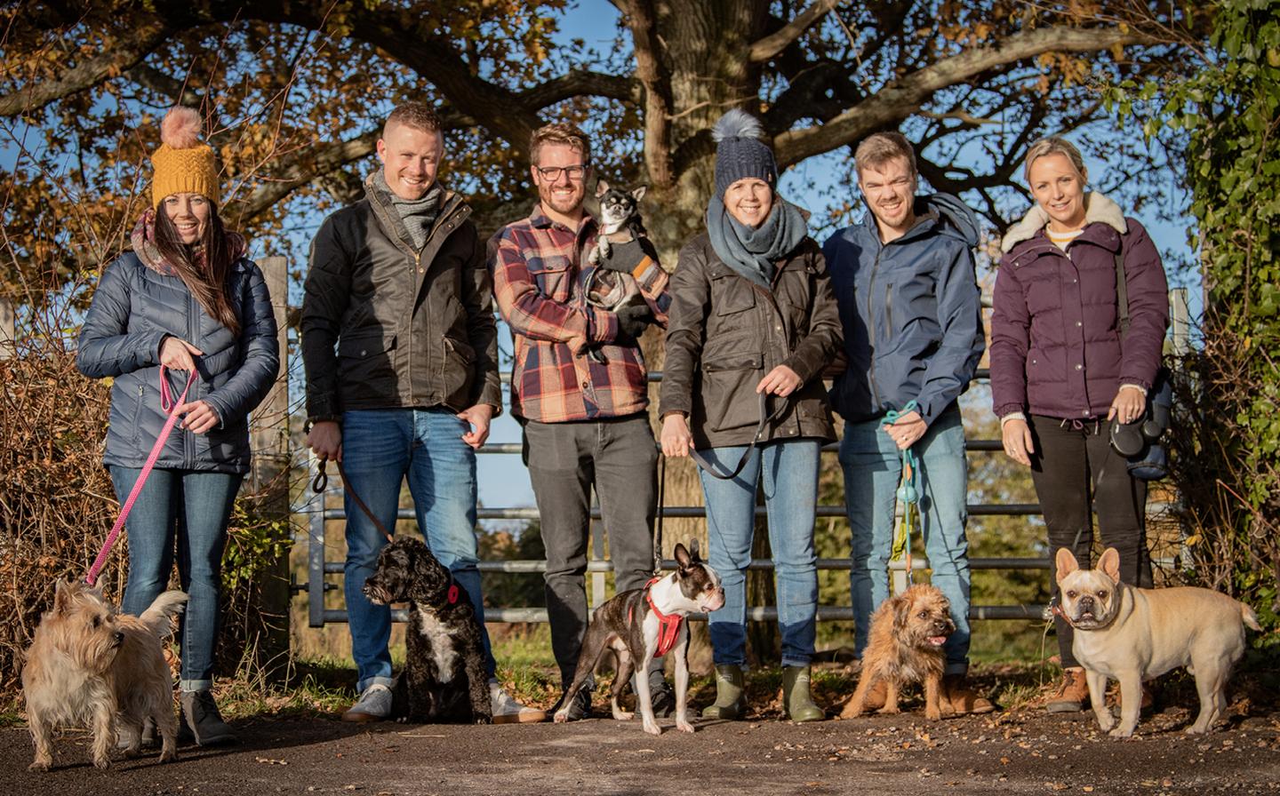 The FatFace crew lined up with their dogs for a group photo, while wearing cosy coats and jackets