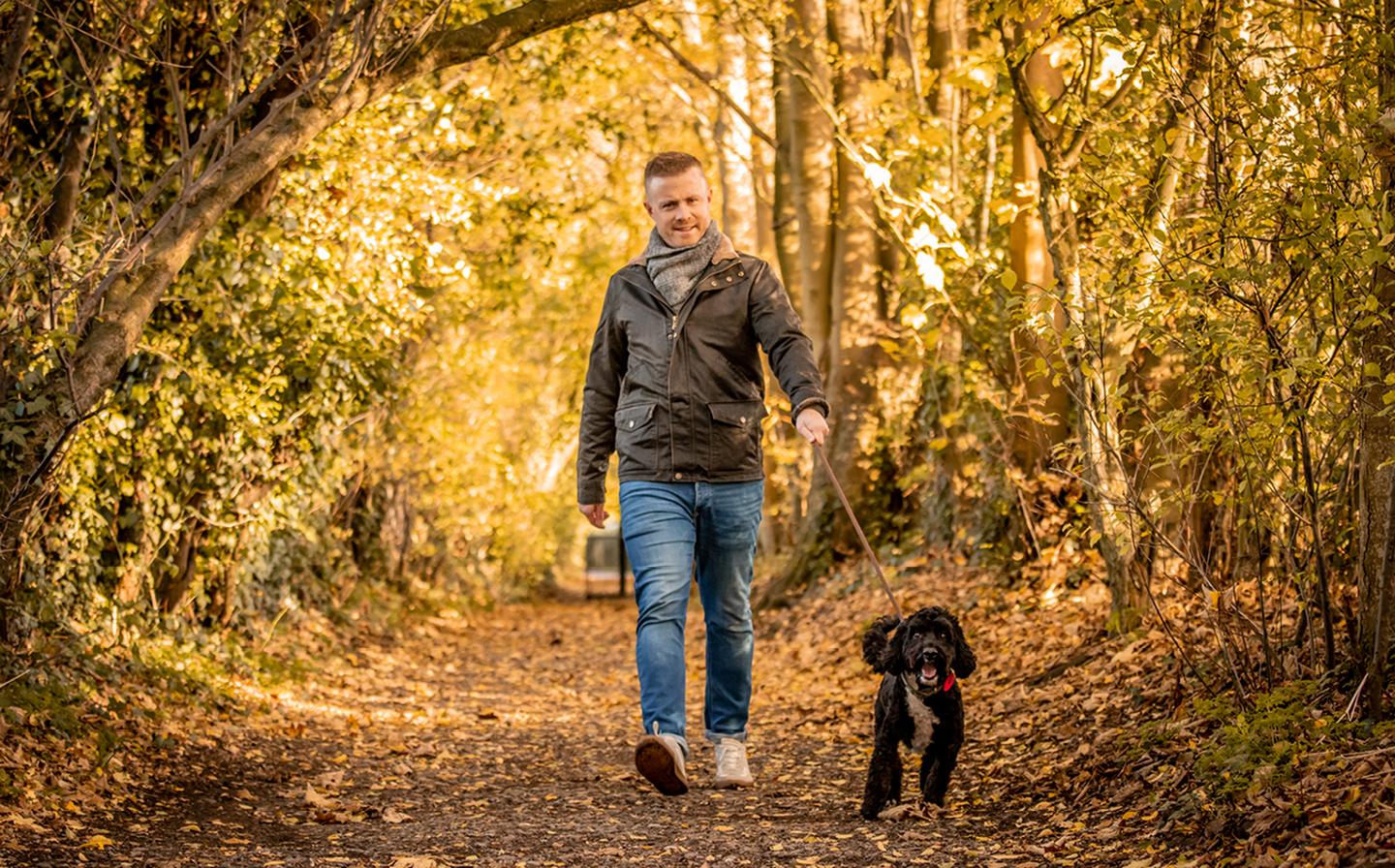 Lee, who works at FatFace HQ, taking his Cockapoo Balthy for a walk through the woods while wearing the Broadsands Jacket