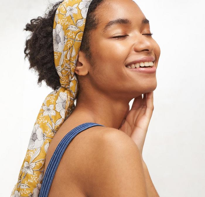 A yellow printed FatFace scarf being used as a headband