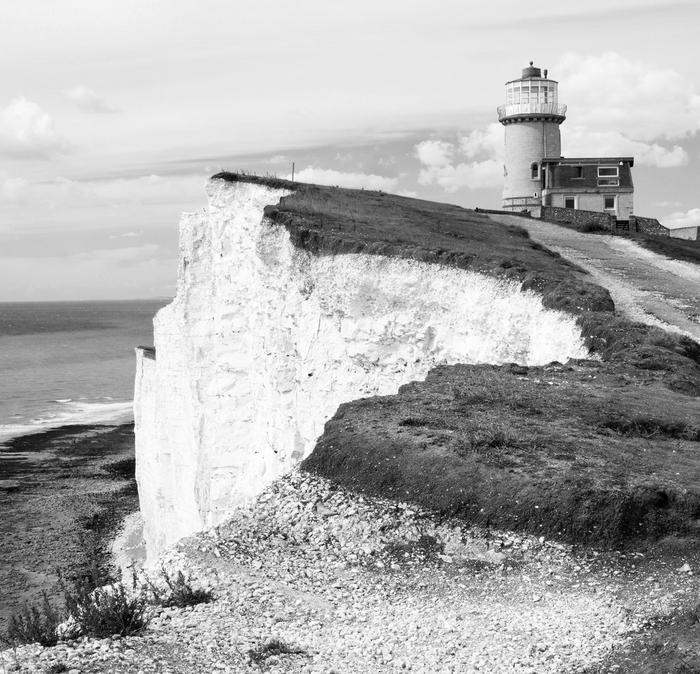 Chalky cliffs at Seven Sisters with a lighthouse at the top.