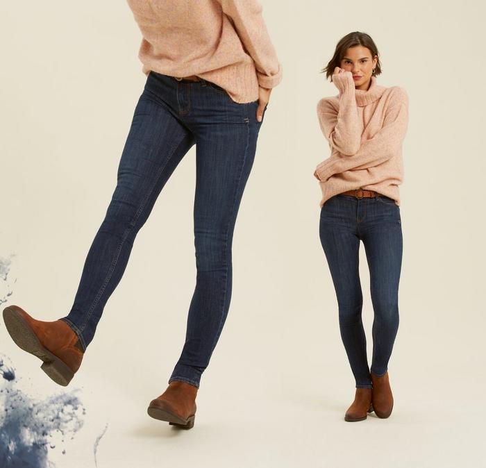 A female model wearing our super skinny fit Harlow Jeans, paired with a pink turtleneck jumper and leather ankle boots.
