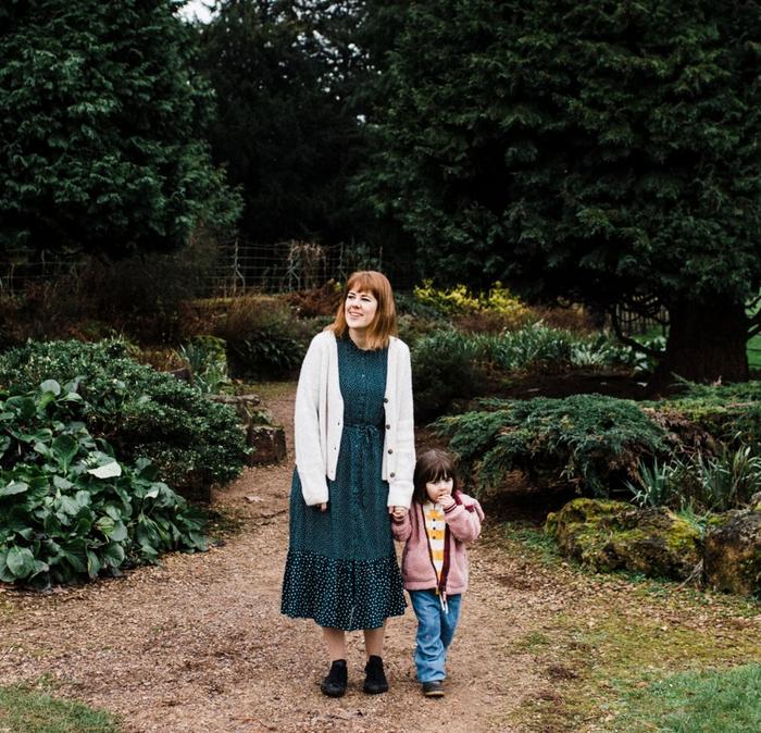 A woman and a girl stood in a garden wearing FatFace clothes.