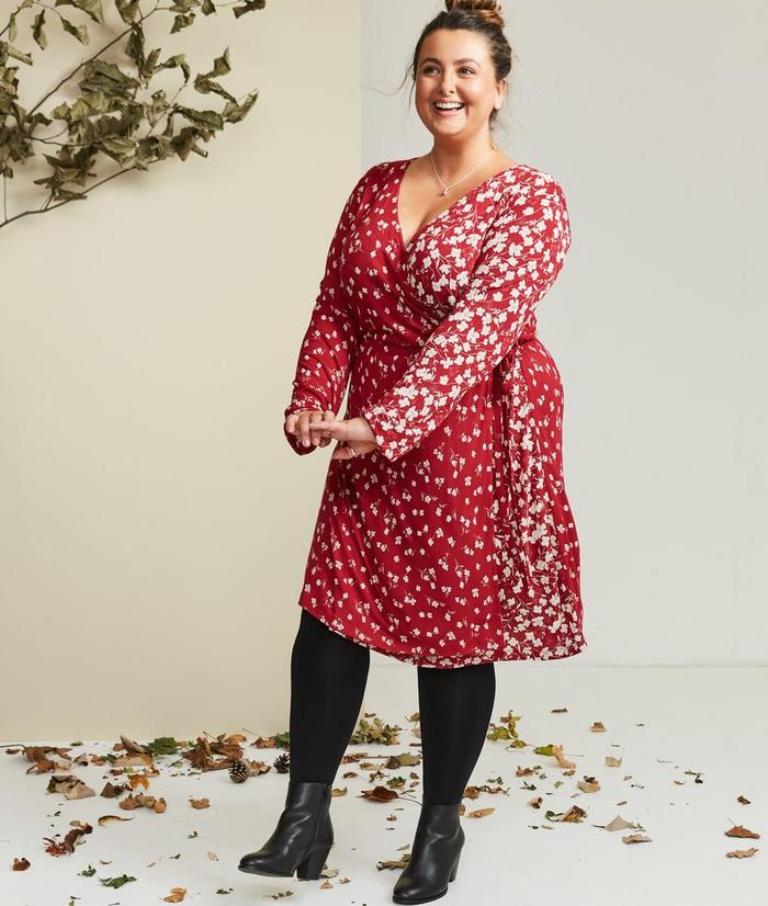 Instagrammer Abee Hague wearing a red and white floral print wrap dress with black tights and boots.