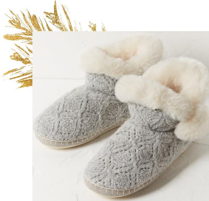 Pale gray cable knit slipper boots with fluffy white trim.