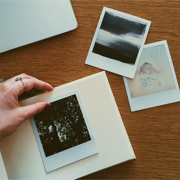 A person arranging polaroid photos.
