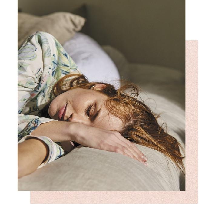 A woman sleeping in floral pyjamas.
