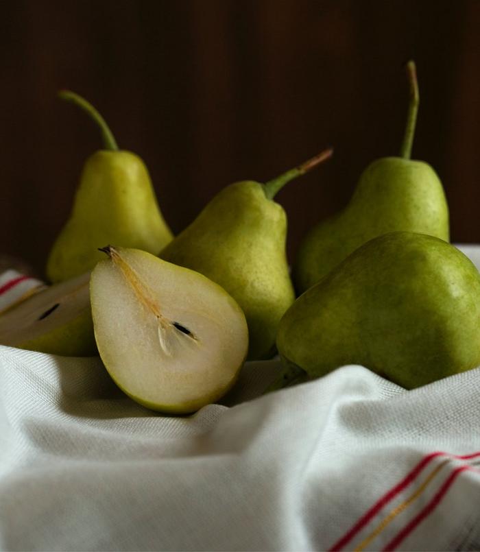 Perfect green pears, some cut in half.