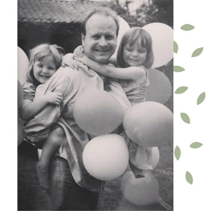 A family photo featuring Annabel's Dad carrying her & her sister, surrounded by balloons.
