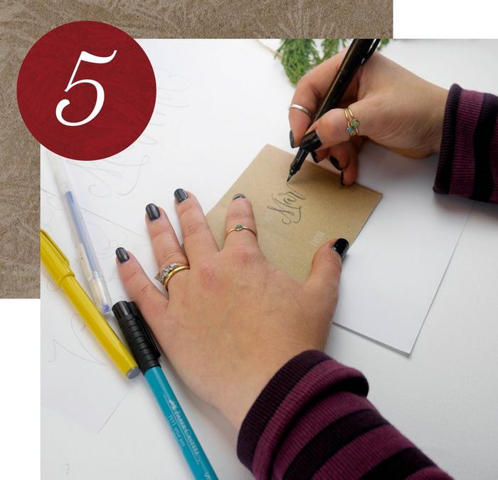 Step 5. A woman using a black pen to write a name on a cardboard gift tag.