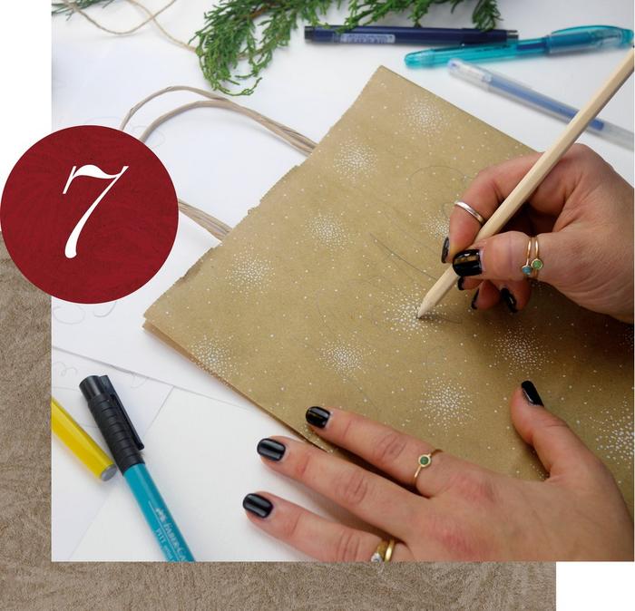 Step 7. A woman using a pencil to do calligraphy on a recyclable paper bag.