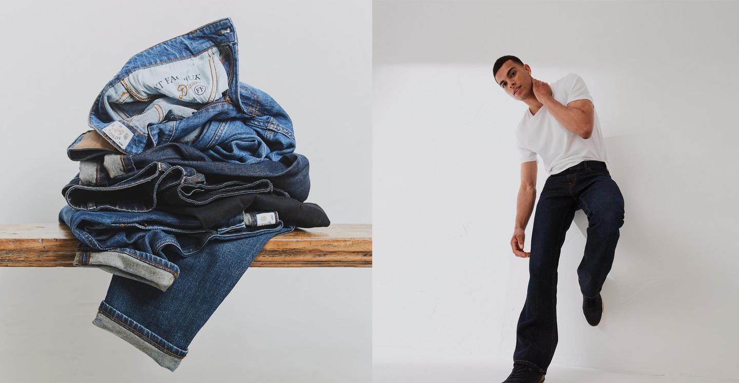 Man wearing a white T-shirt and dark-wash bootcut jeans, and a pile of FatFace denim jeans in various washes.