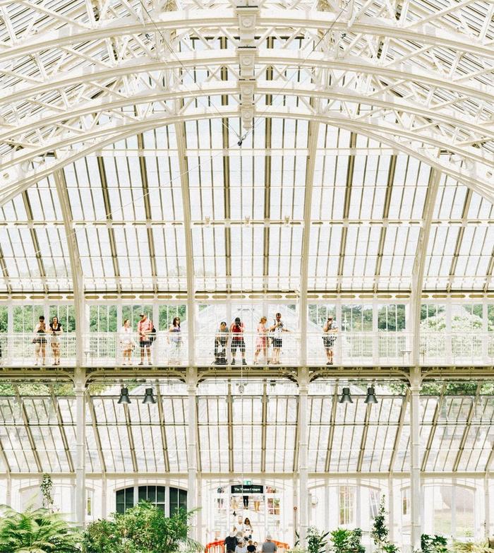 Visitors take in the view from the raised walkway of the vast steel and glass Temperate House at Kew Gardens.