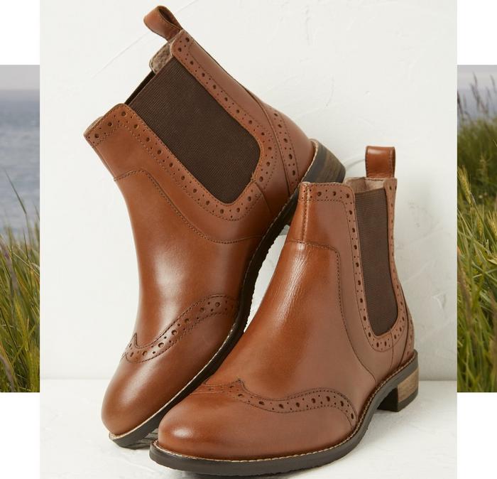 A pair of tan-brown women's Chelsea boots with debossed detailing.