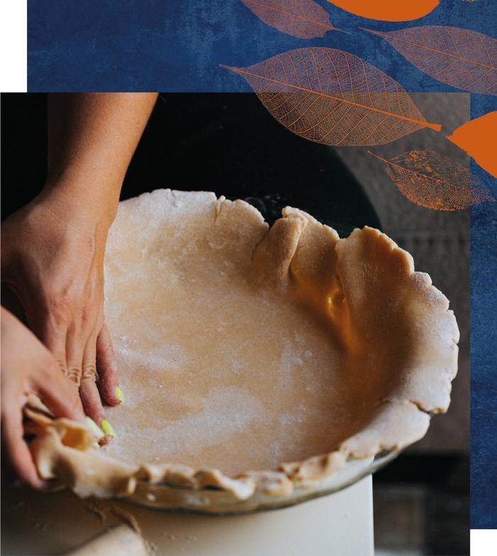 A person pressing rolled short crust pastry into a dish for baking.