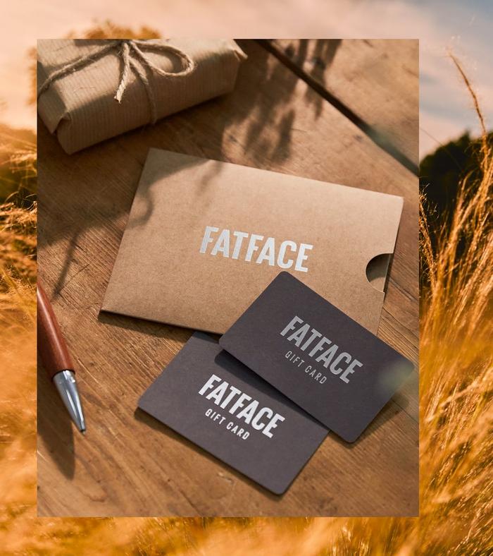 A pair of FatFace gift cards with a cardboard sleeve & a pen.