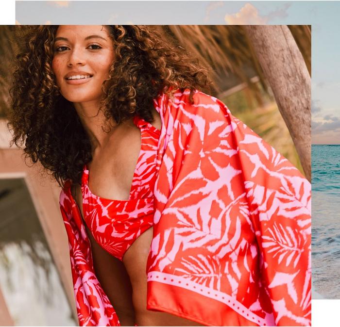 A woman wearing a bright red & pink tropical leaf print bikini & matching cover-up.