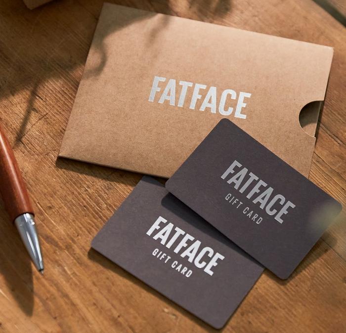 A pair of FatFace gift cards with a cardboard sleeve & a pen.