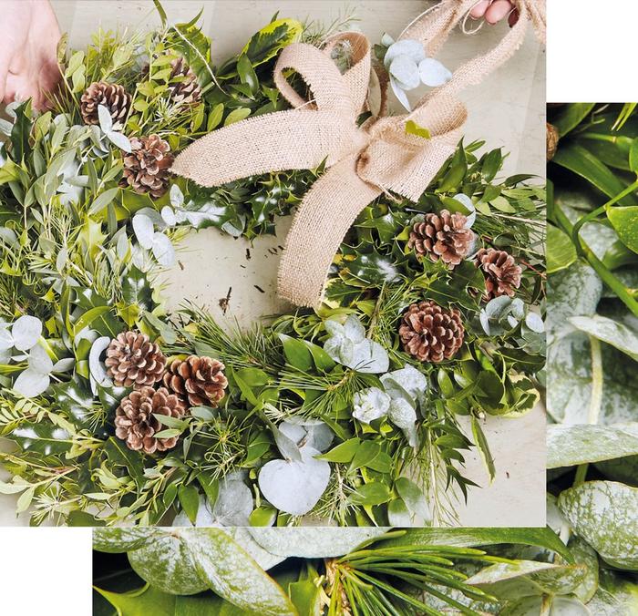 A hessian bow & pinecones add festive detail to a wreath.