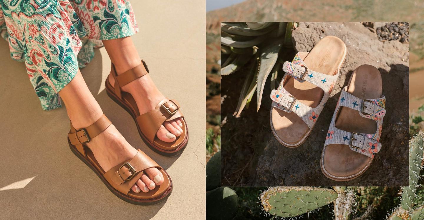 A woman wearing tan leather flatform buckle sandals. A pair of embroidered ivory slide-on sandals with double buckle straps.