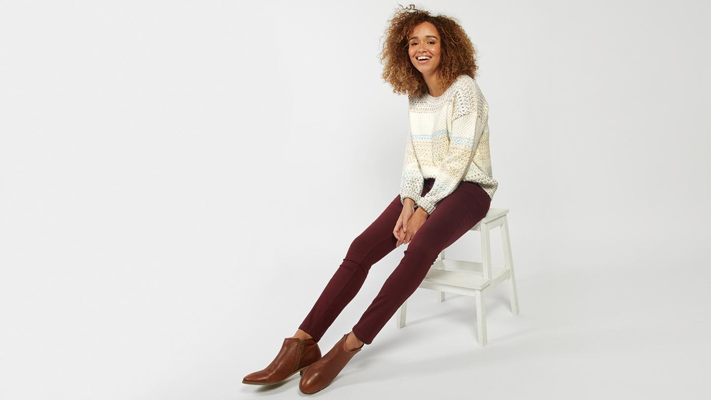 The Five Pocket Jeggings in Tuscan Red, layered with boots and a jumper