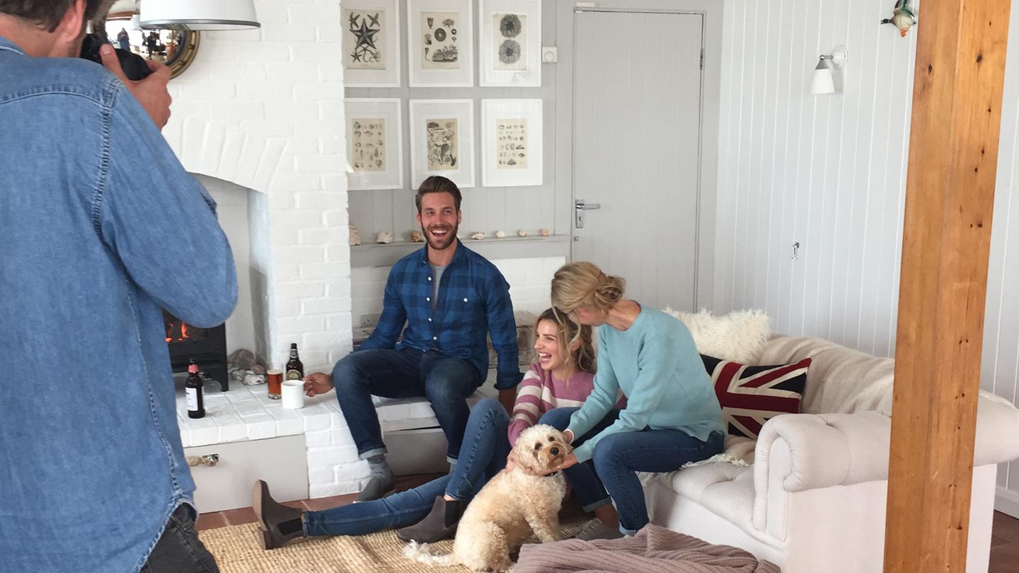 Three models and a dog on a photoshoot in a lounge