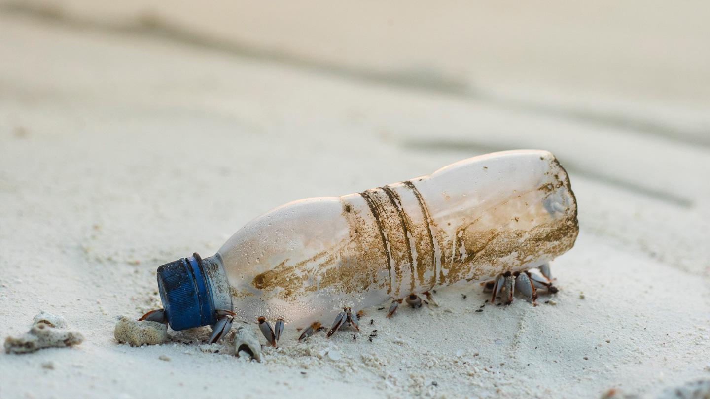 Litter and glass bottles strewn across a pebbled beach in the UK