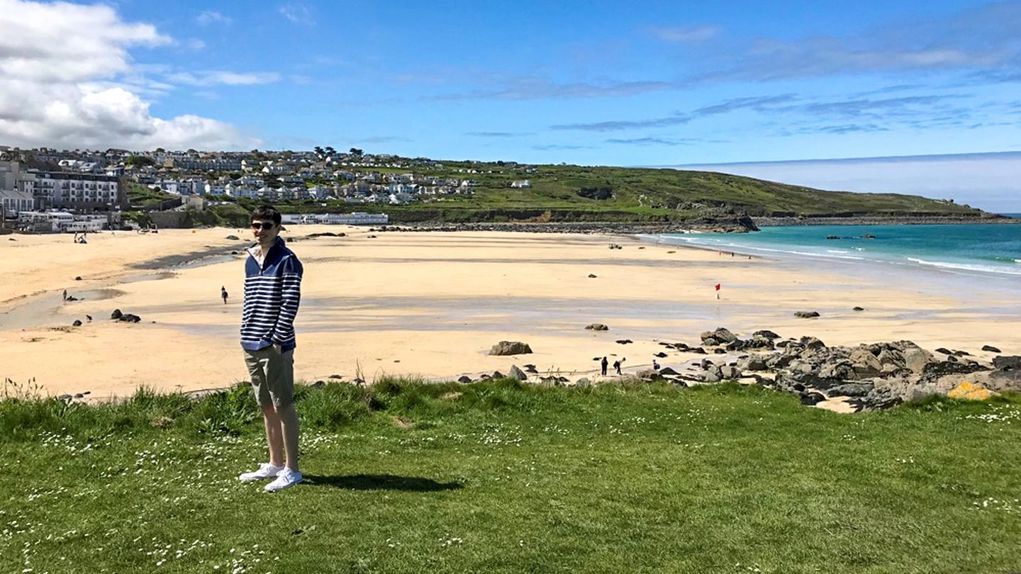 Daniel, who works at the FatFace store in St Ives, wearing FatFace clothes on the cliffs of the beach in St Ives
