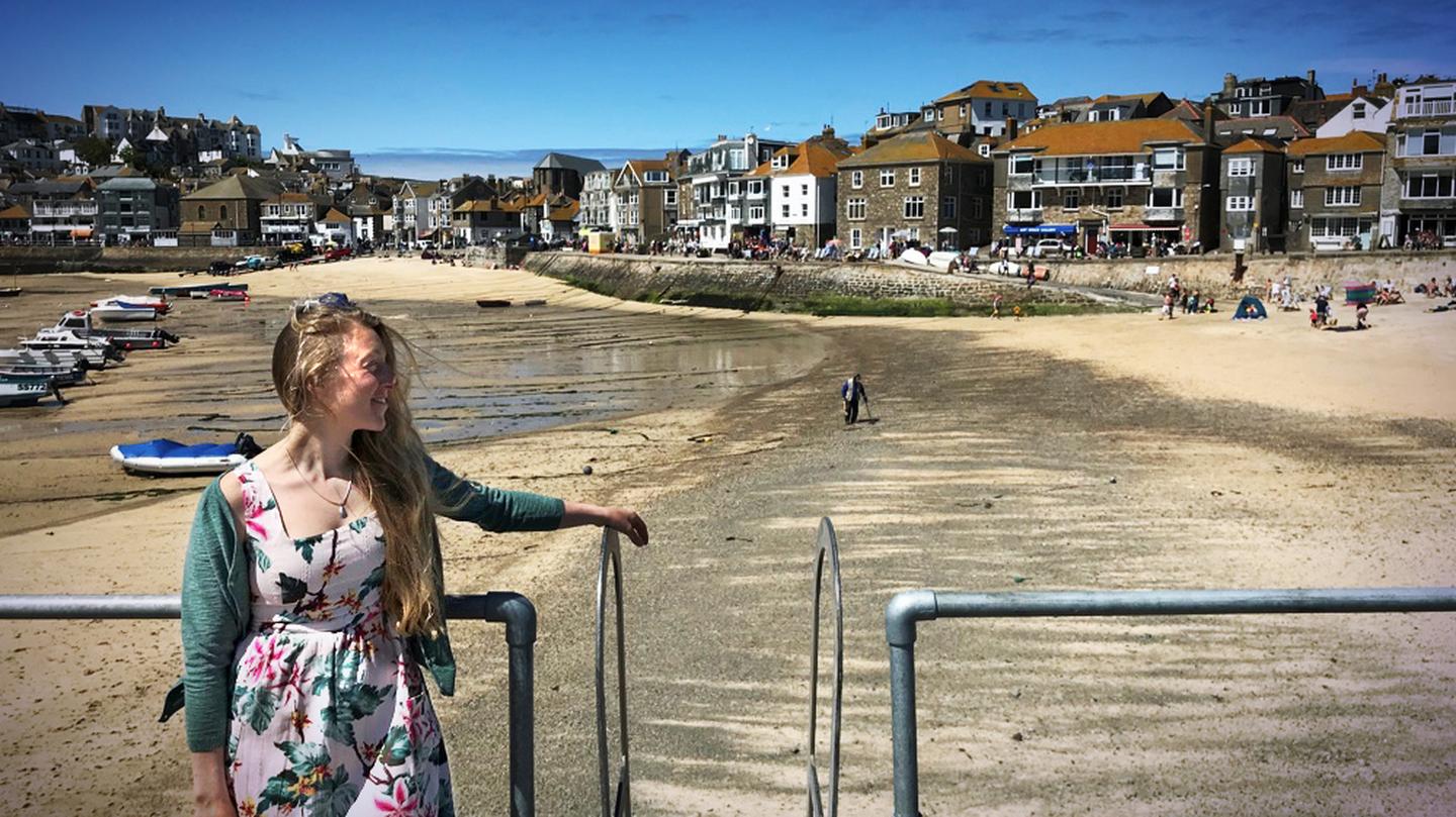 Poppy, who works at the St Ives FatFace store, against the beautiful backdrop of the local beach at St Ives