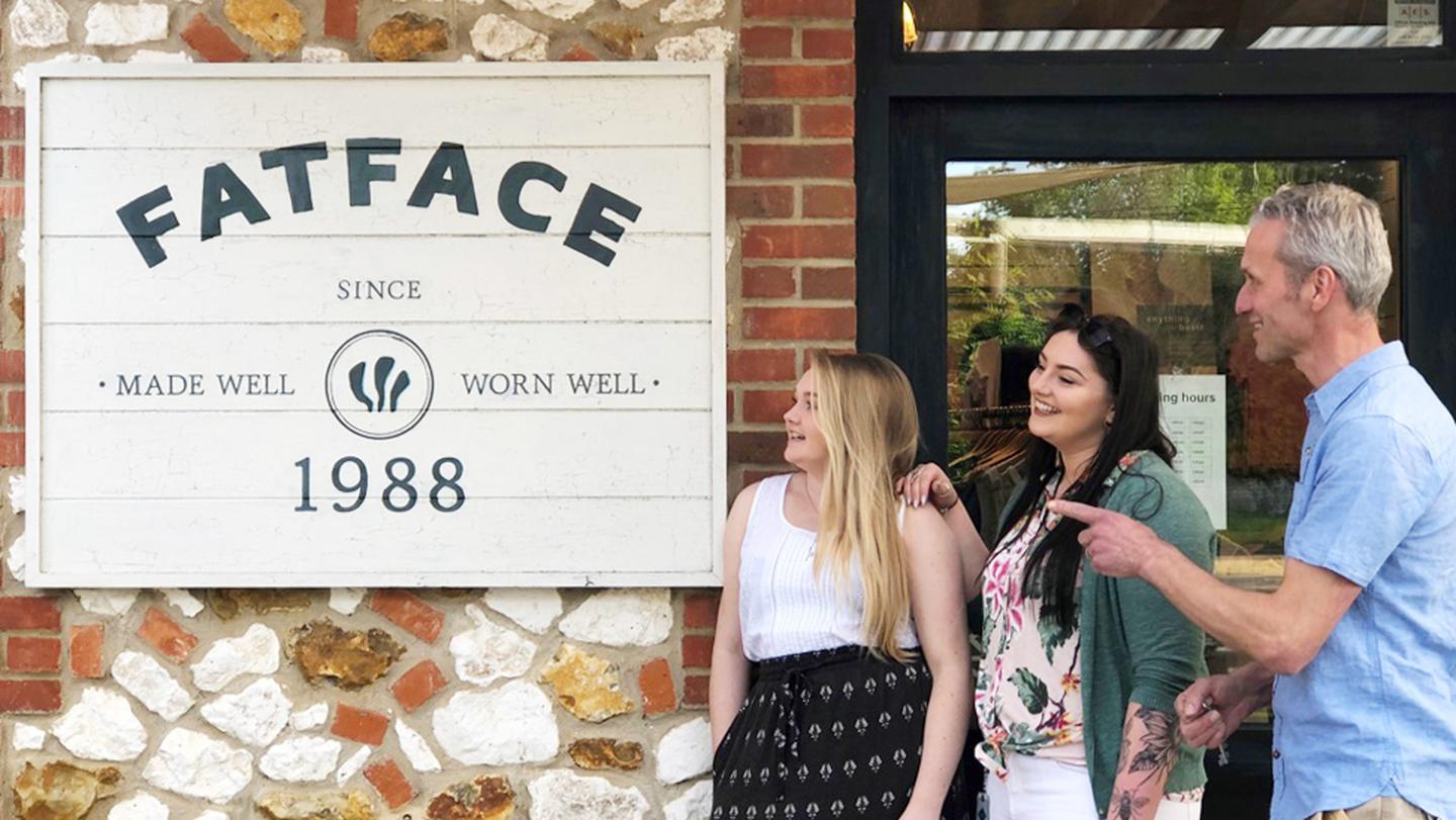 The FatFace store crew at Burnham Deepdale, posing next to their shop sign in FatFace clothes