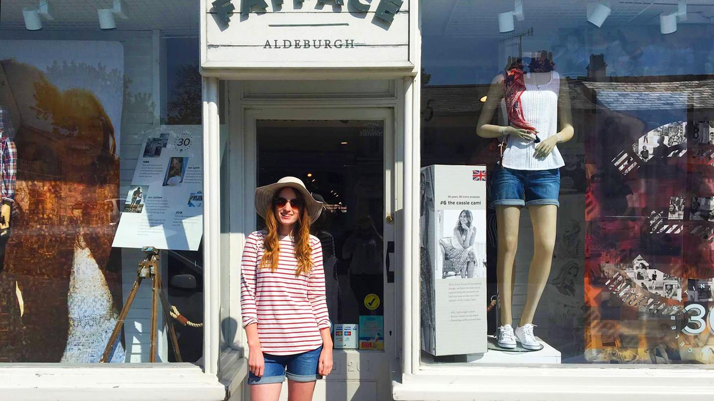 Cecily, who works at the FatFace store in Aldeburgh, standing in front of the store in FatFace clothes