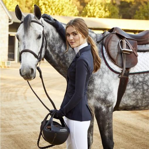 Woman wearing English riding gear with horse