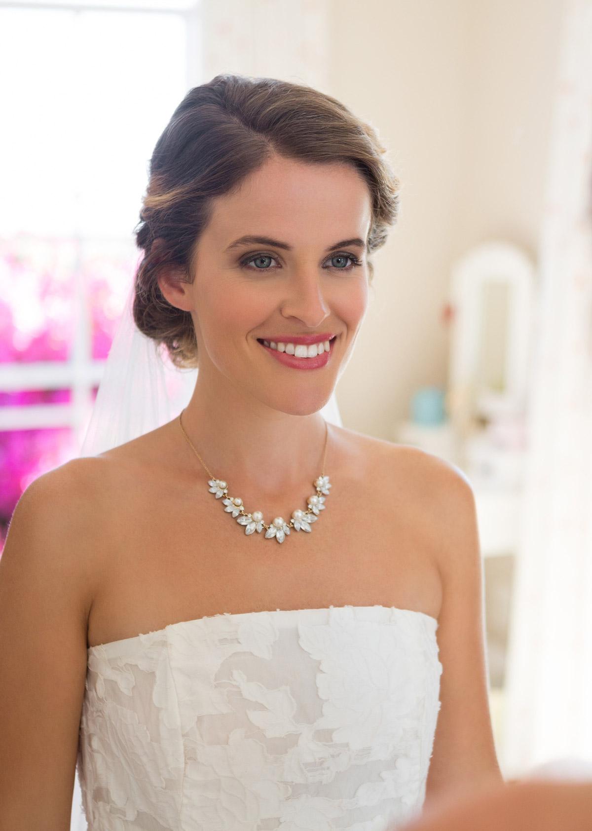 Close up image of a bride wearing a statement diamond necklace and strapless wedding dress