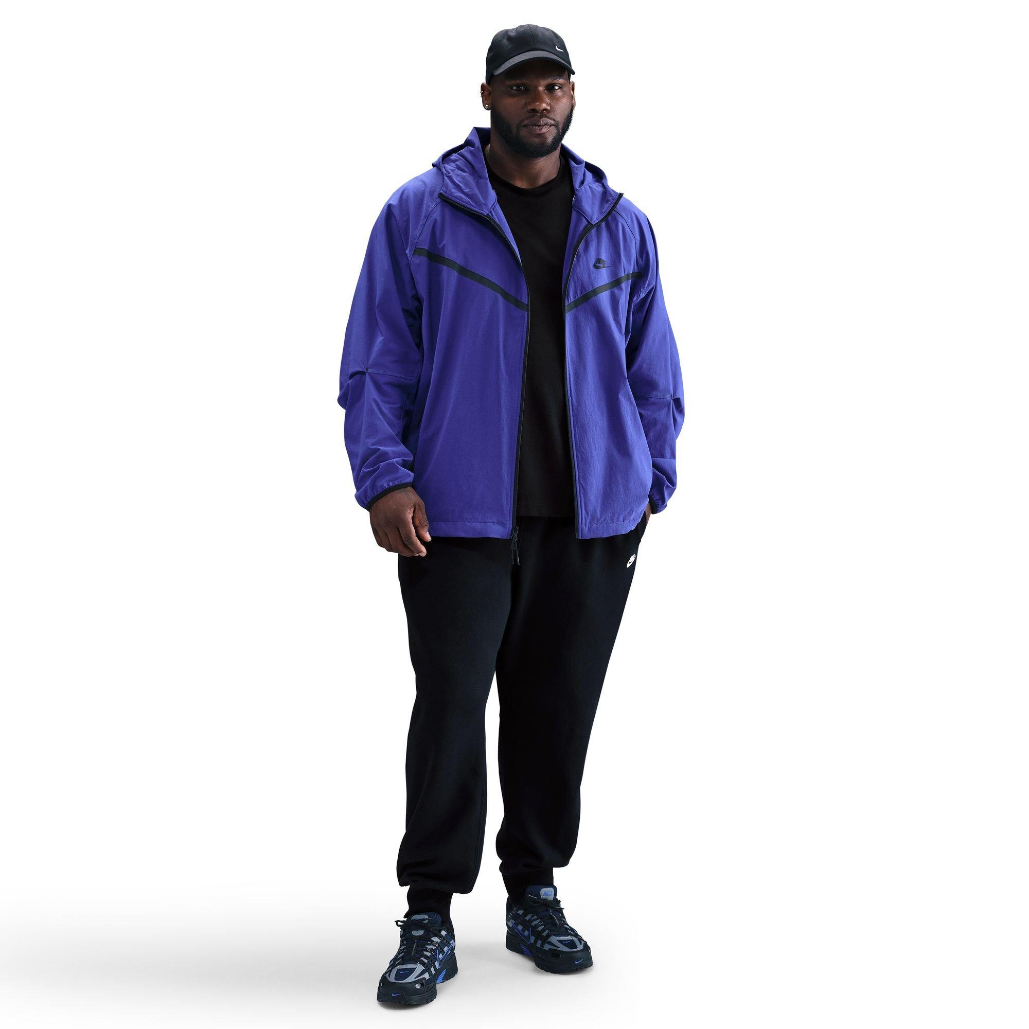 Men wearing black Nike Club Joggers layered with purple jacket and sneakers for styling inspiration