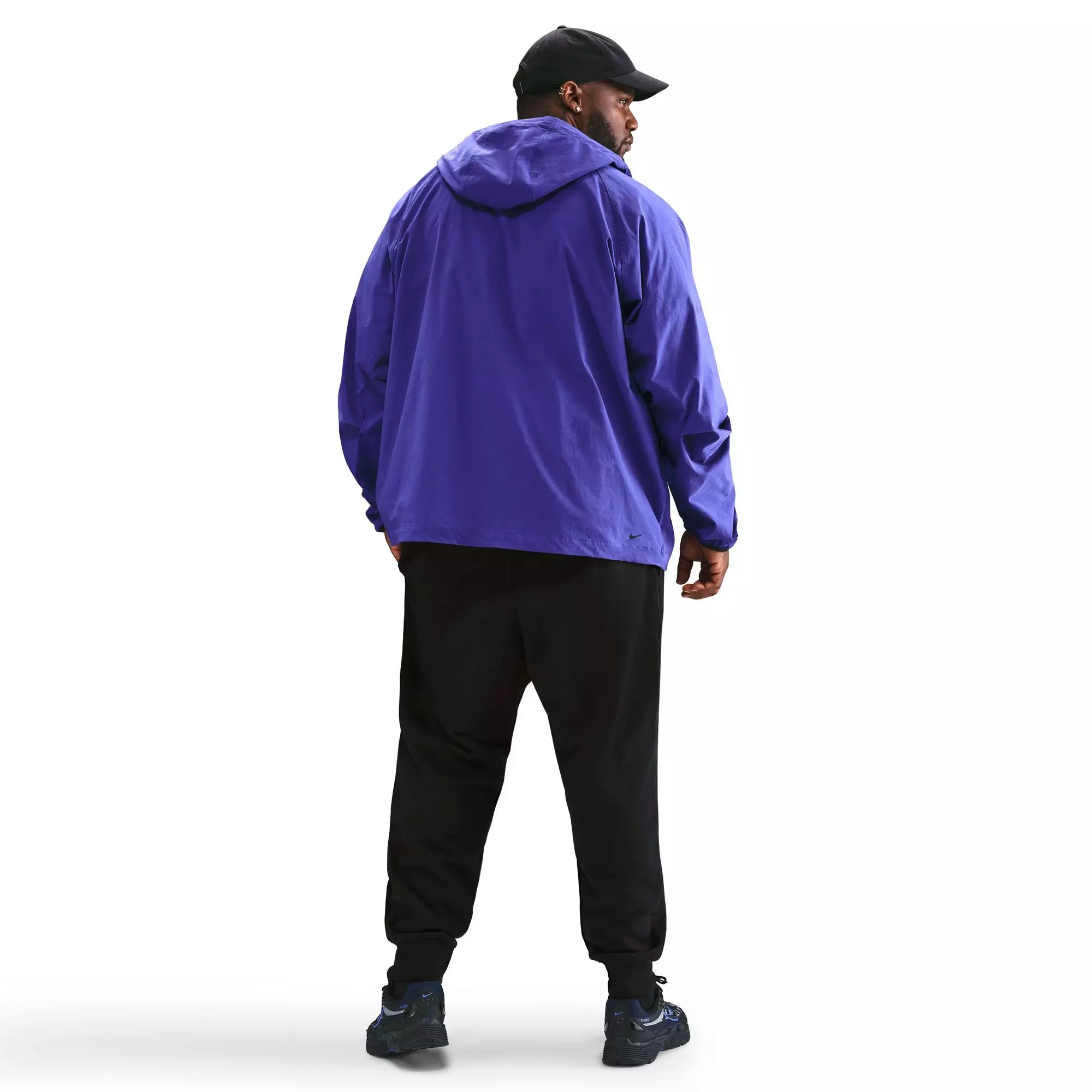 Back view of man wearing black Nike Club Joggers with purple jacket showing relaxed fit and length