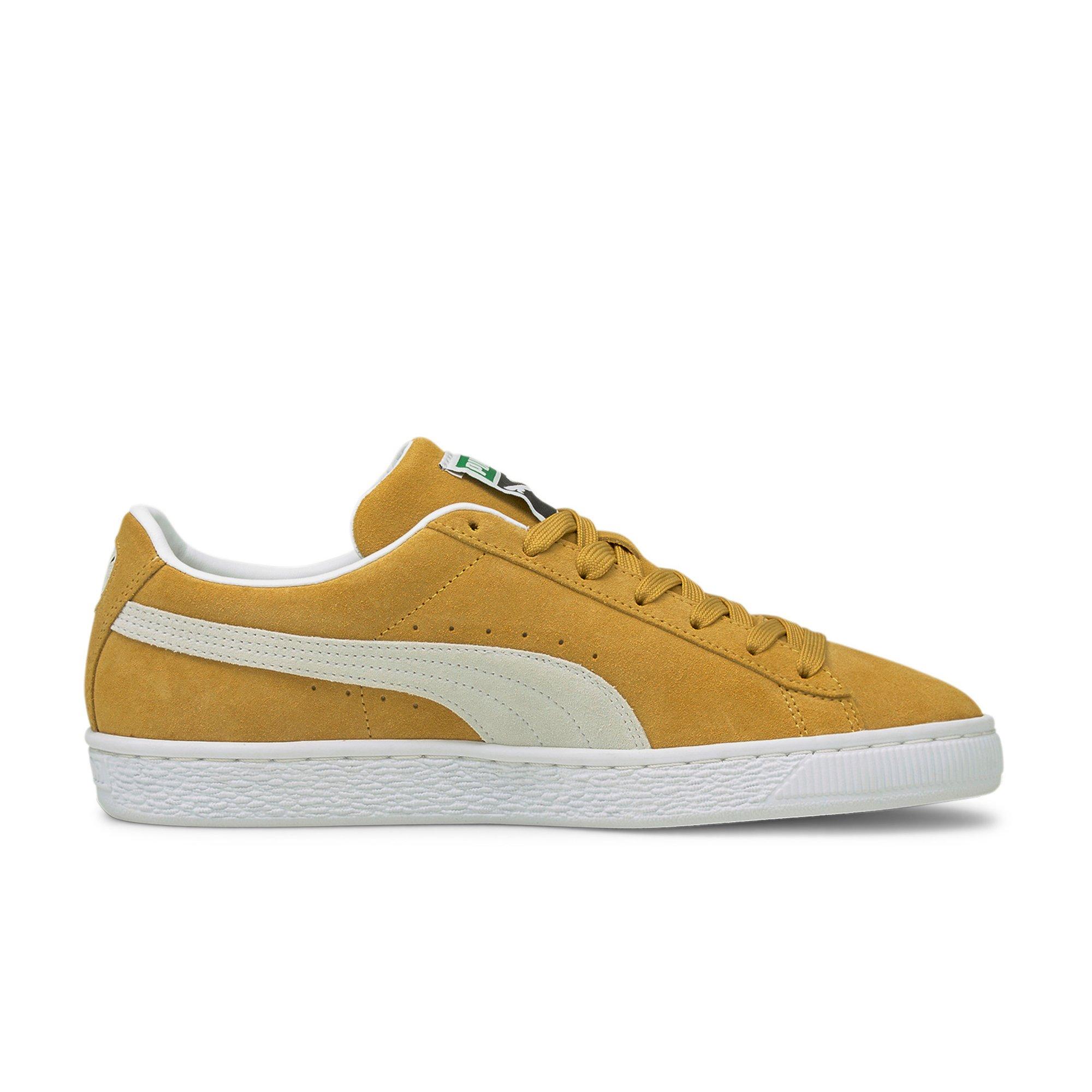 yellow and white suede pumas