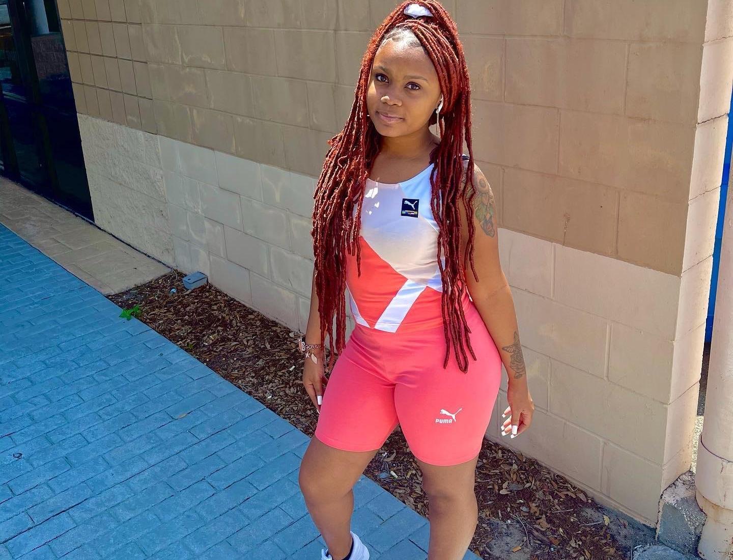 Woman in pink Puma biker shorts and a pink and white Puma tank.