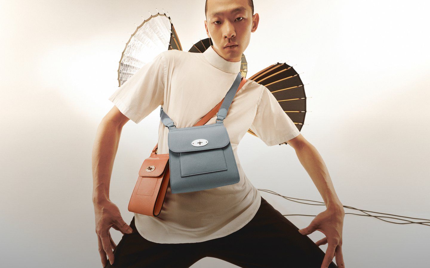 Male model wearing two Antony bags